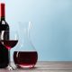 Imagen de una botella, un vaso llenos de vino tinto imprescindibles para aprovechar las propiedades saludables