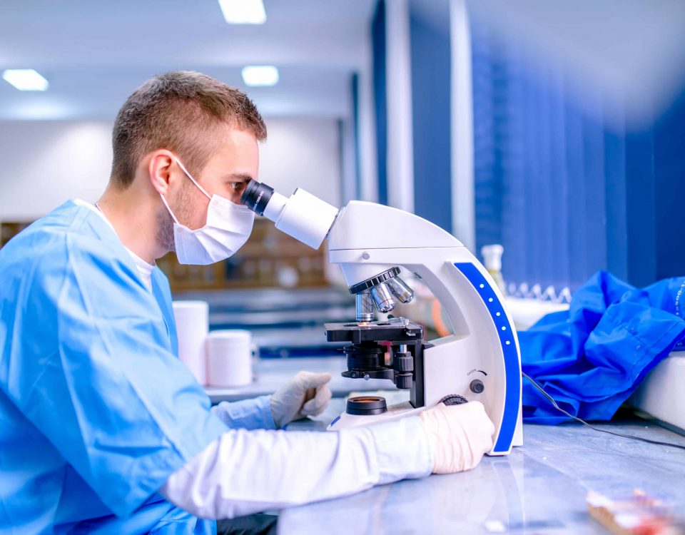 hombre mirando a través de un microscopio