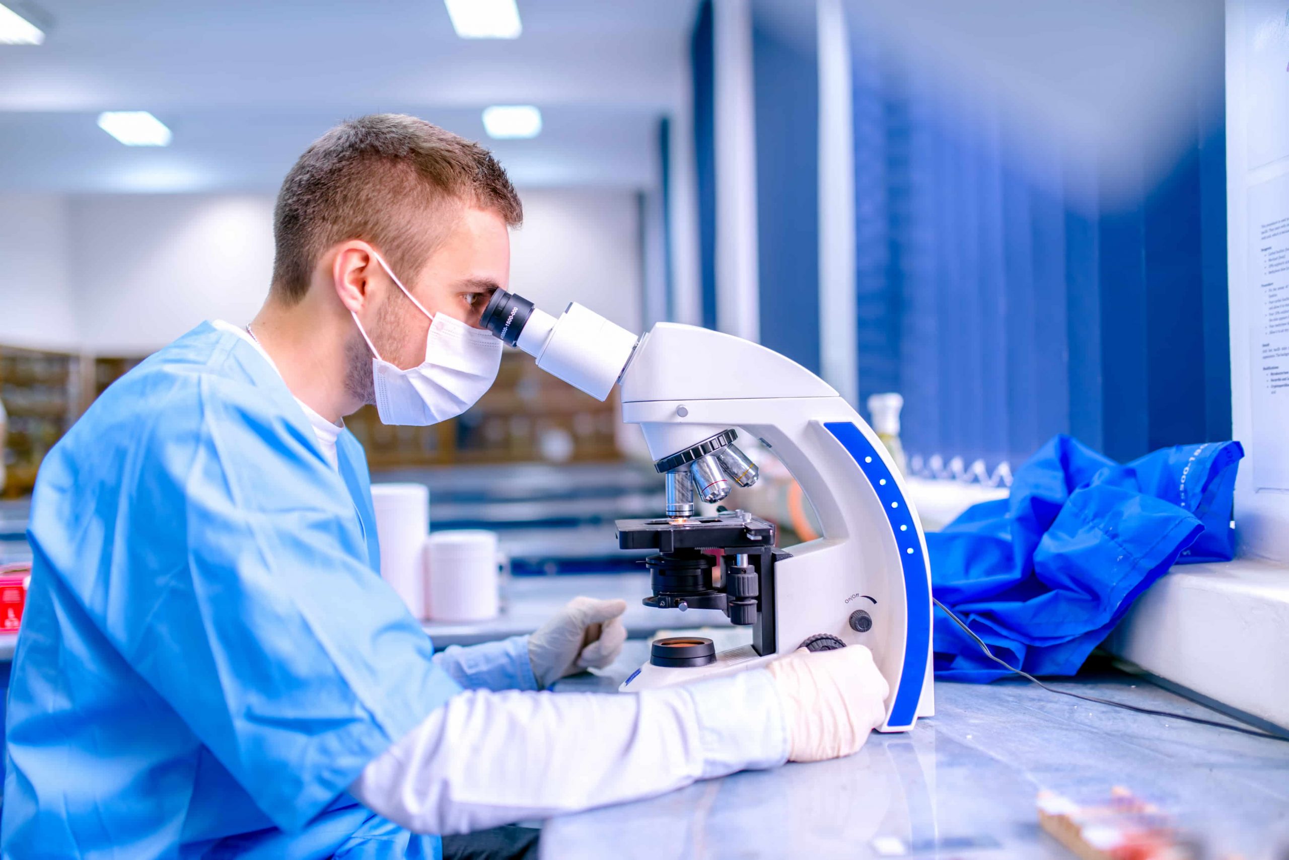 hombre mirando a través de un microscopio