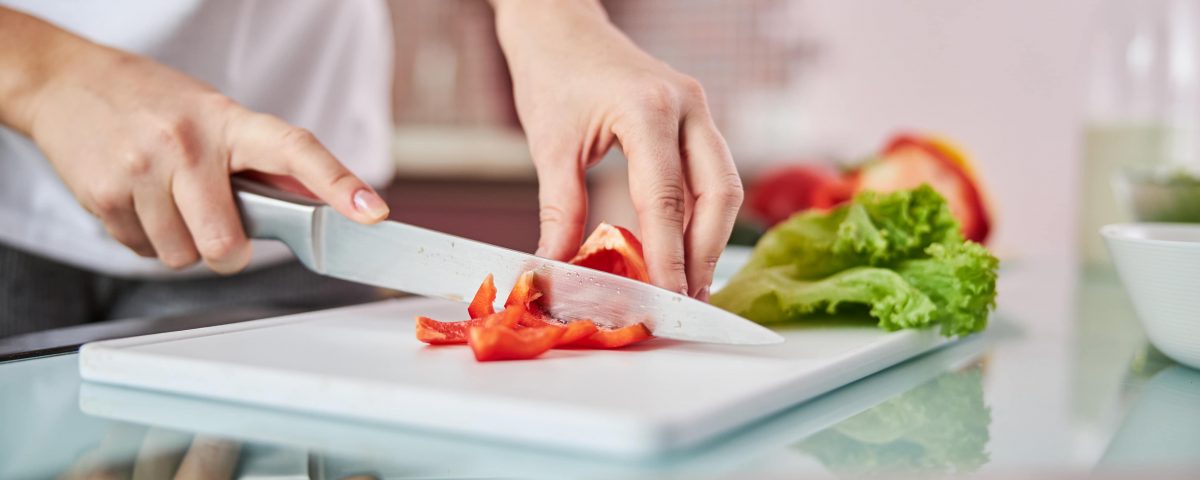 imagen de un pimiento cortándose en una tabla de cortes en perfectas condiciones higiénicas