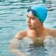 hombre en una piscina con gorro y gafas de bucear