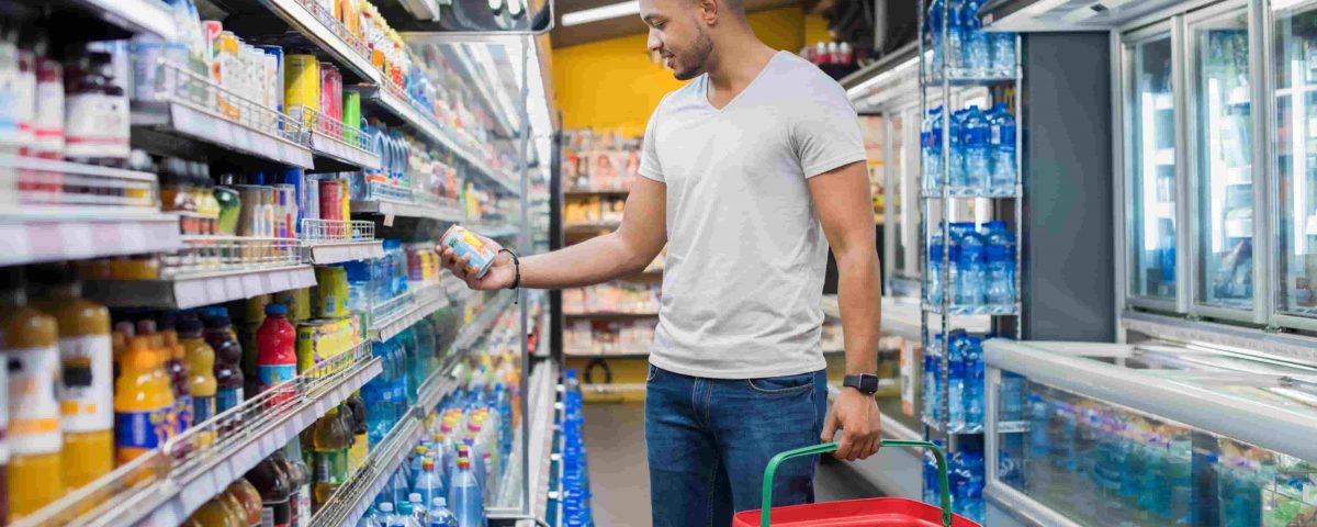 hombre en el supermercado eligiendo alimentos envasados