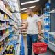 hombre en el supermercado eligiendo alimentos envasados