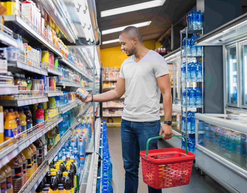 hombre en el supermercado eligiendo alimentos envasados