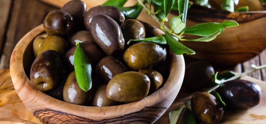 aceitunas en un tarro con ramas de olivo