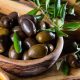 aceitunas en un tarro con ramas de olivo