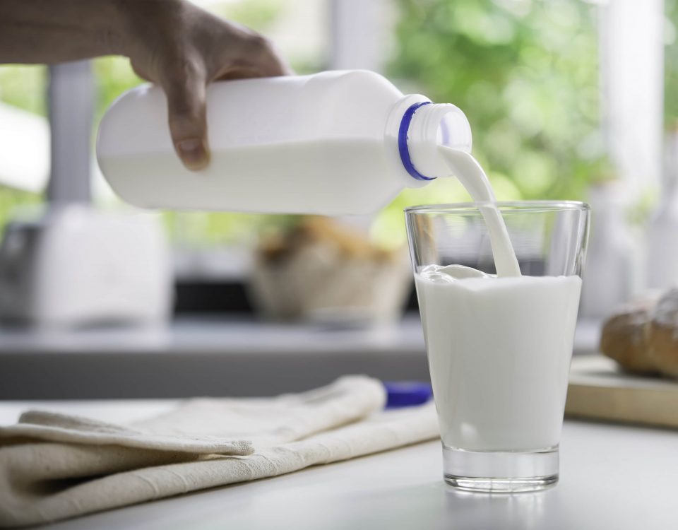 imagen de una mano echando leche cruda en un vaso