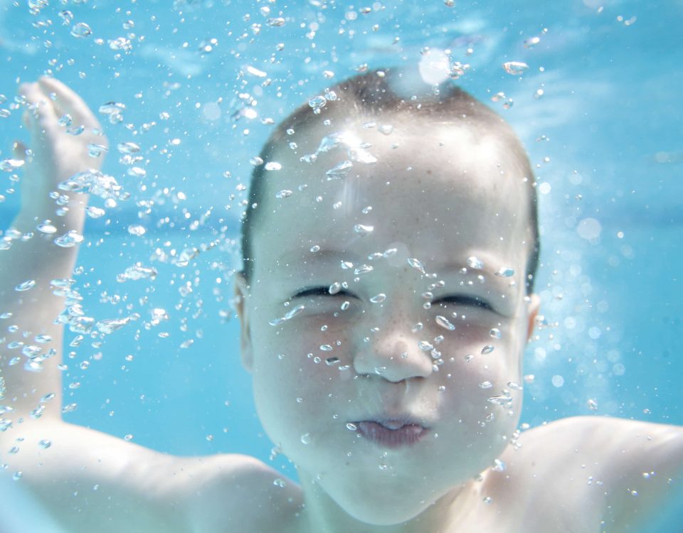 niño pequeño bajo el agua de una piscina
