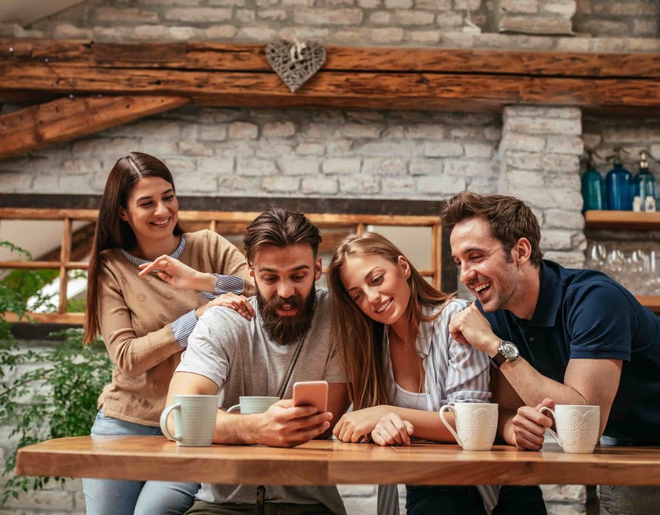 dos hombres y dos mujeres mirando un mismo móvil