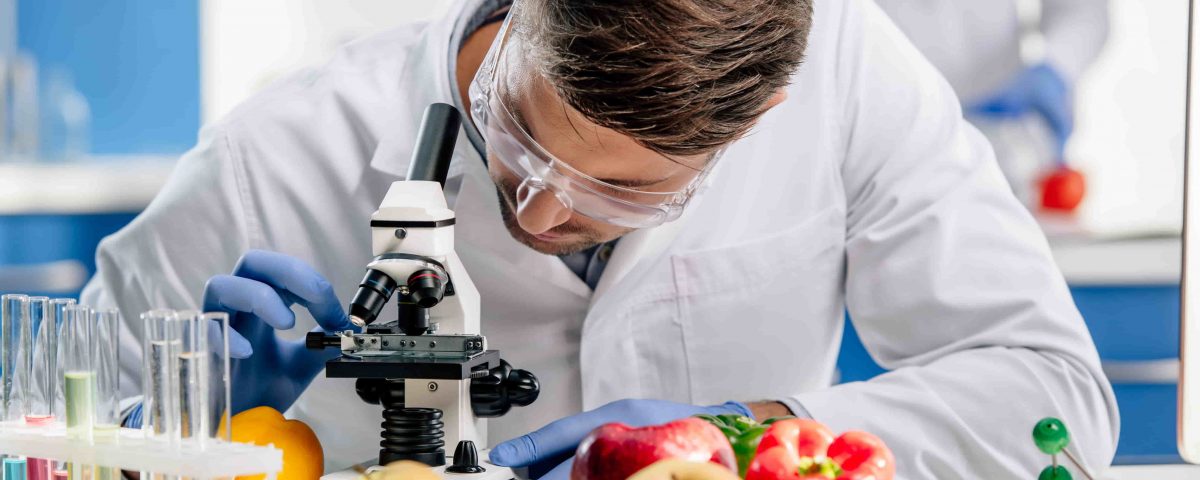 hombre en un laboratorio con fruta realizando investigación de alimentos transgénicos