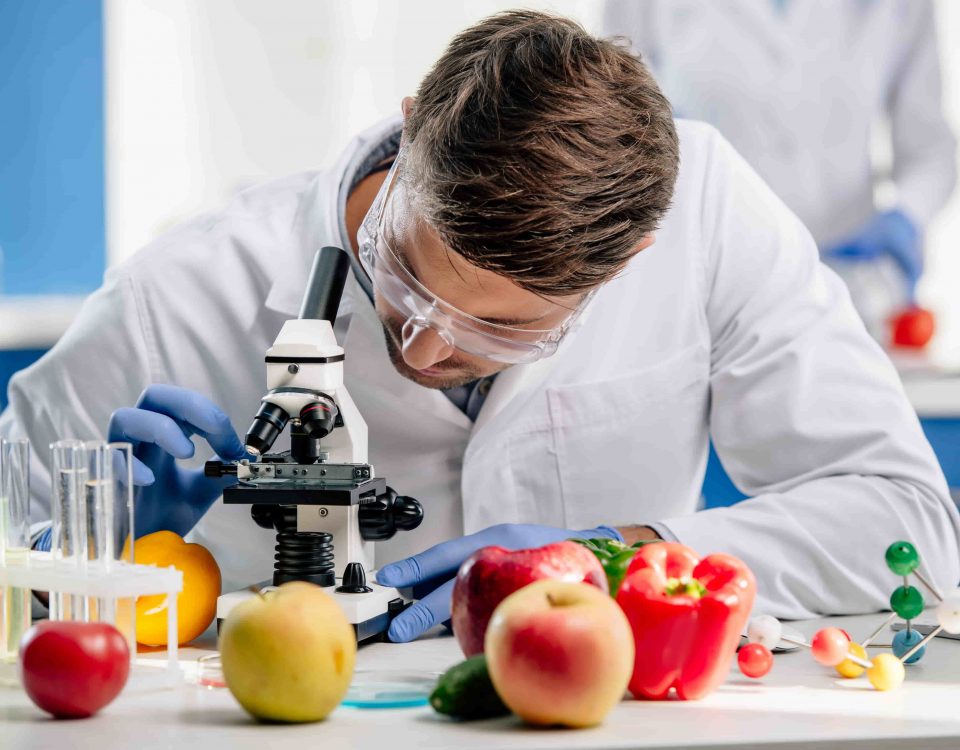 hombre en un laboratorio con fruta realizando investigación de alimentos transgénicos