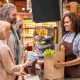 mujer entregando una bolsa de la compra a una pareja