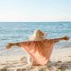 mujer con los brazos abiertos en la playa