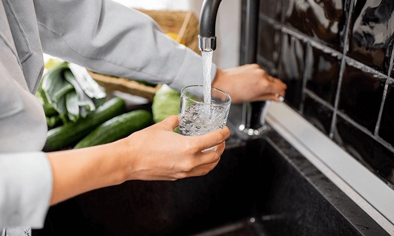 fotografía sirviéndose agua del grifo