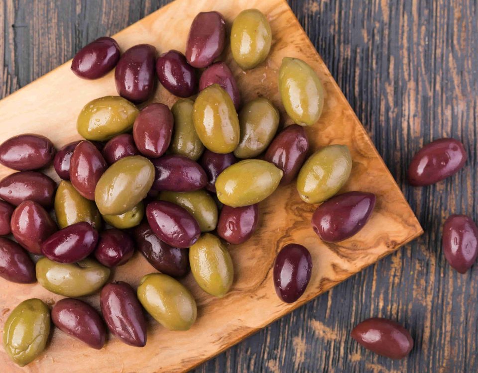 aceitunas verdes y moradas sobre una tabla de madera